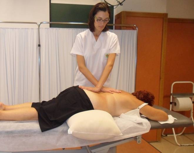 La profesora de Fisioterapia de la CEU-UCH, María Dolores Arguisuelas, aplicando la técnica de relajación miofascial en la zona lumbar de una paciente